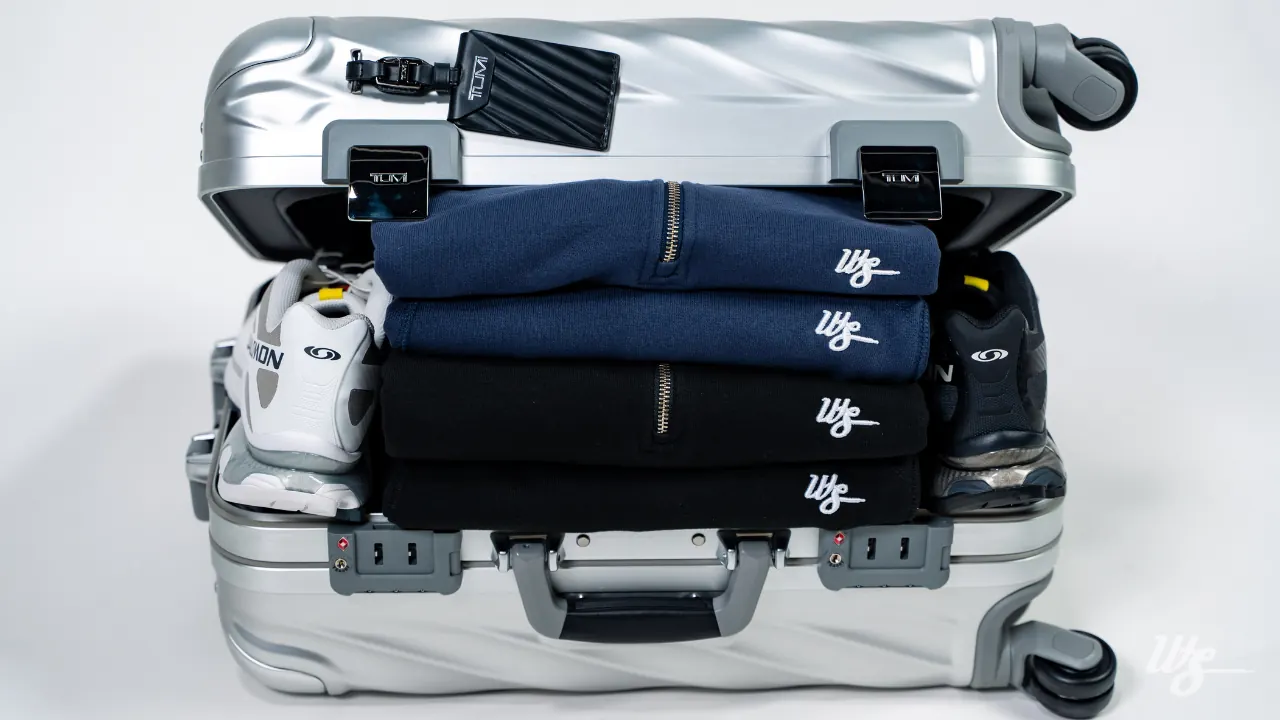Maleta de aluminio abierta con quarter zips y sweatpants WS Layover doblados