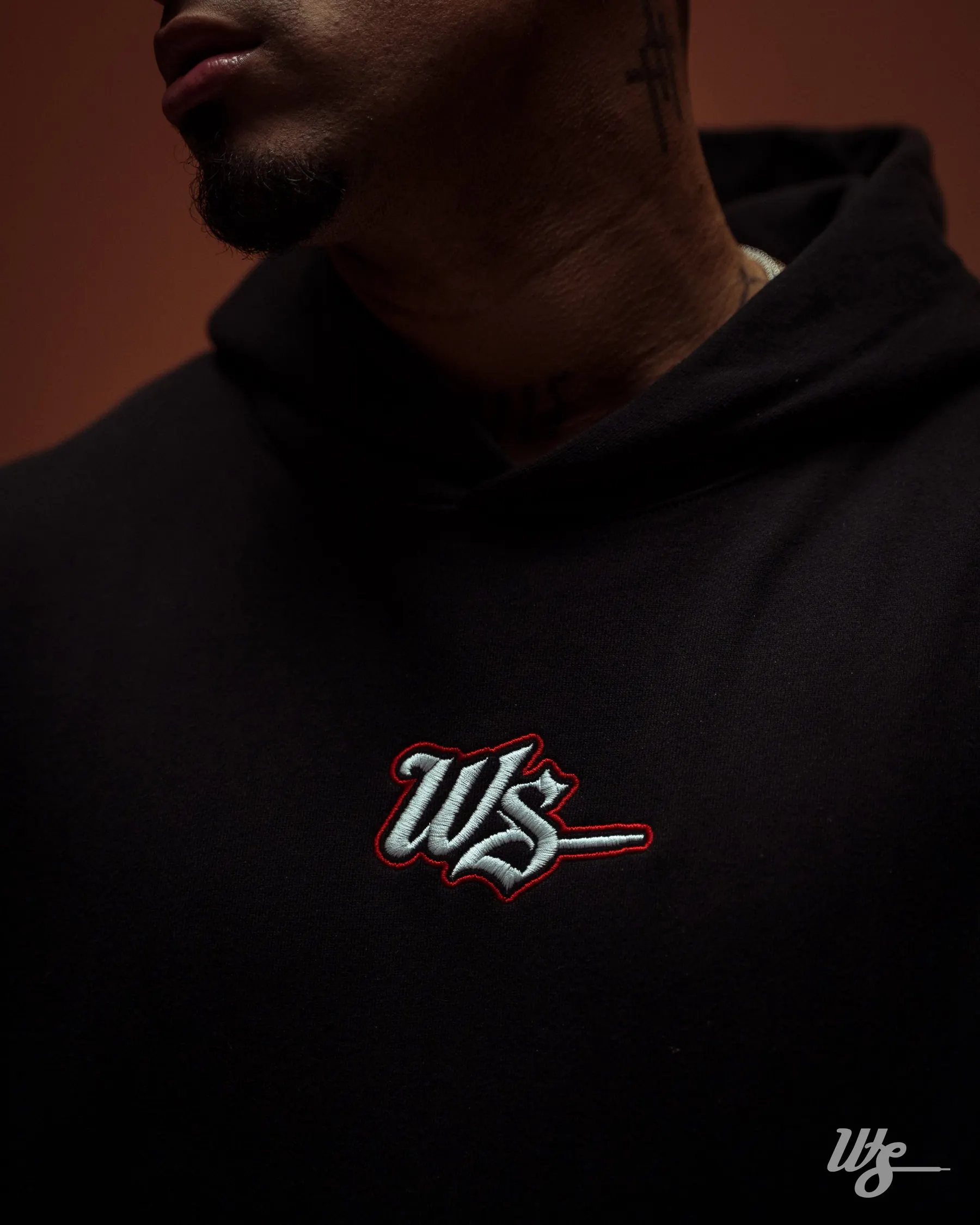 Hoodie negro WS Medieval en estudio de fondo marrón